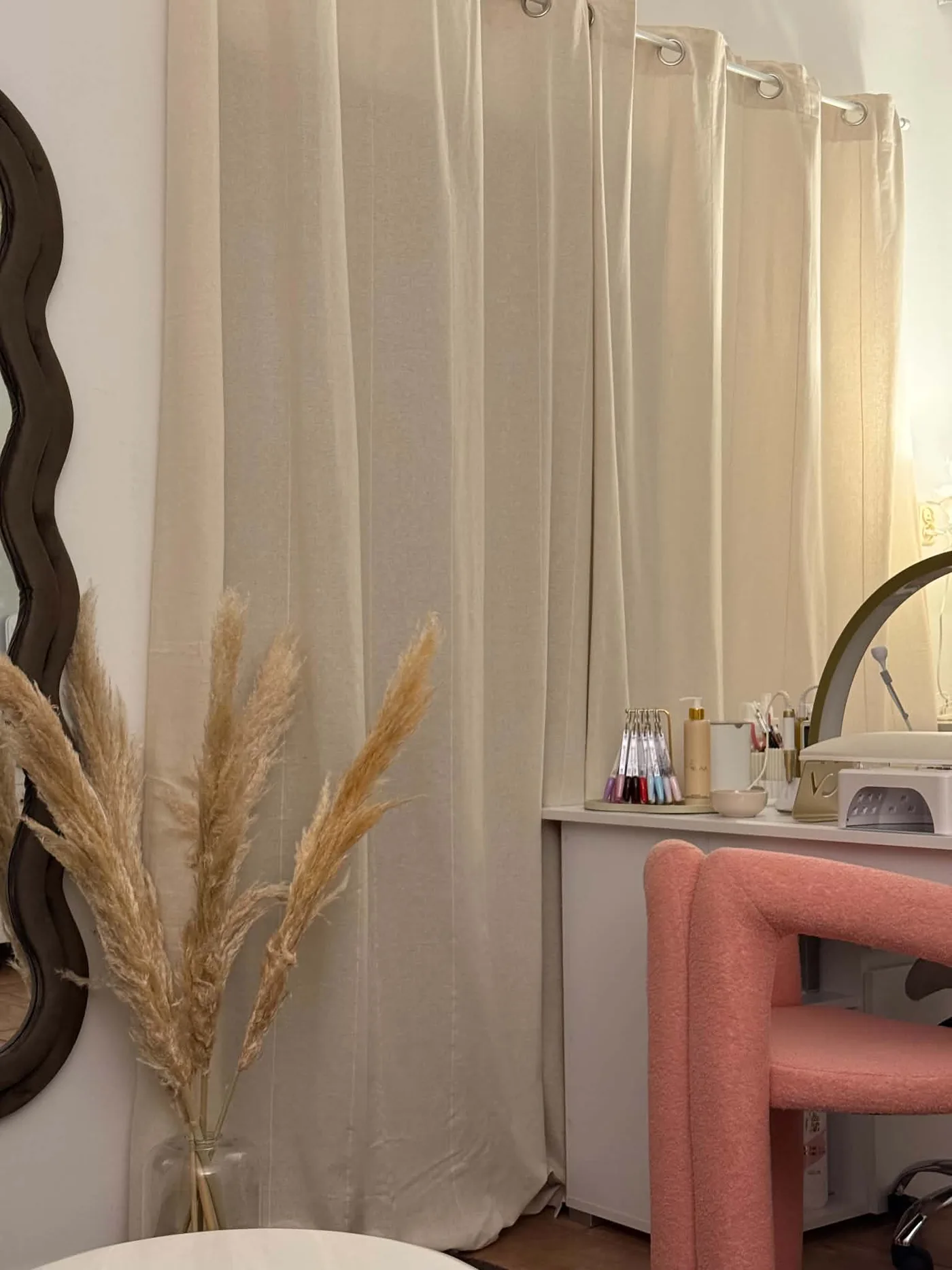 Kącik z pampasami i różowym fotelem bouclé w gabinecie OZAYA Nails w Krakowie