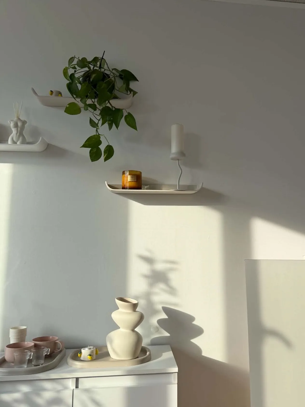 Półki z rośliną, świecą i ceramiką w gabinecie OZAYA Nails w Krakowie