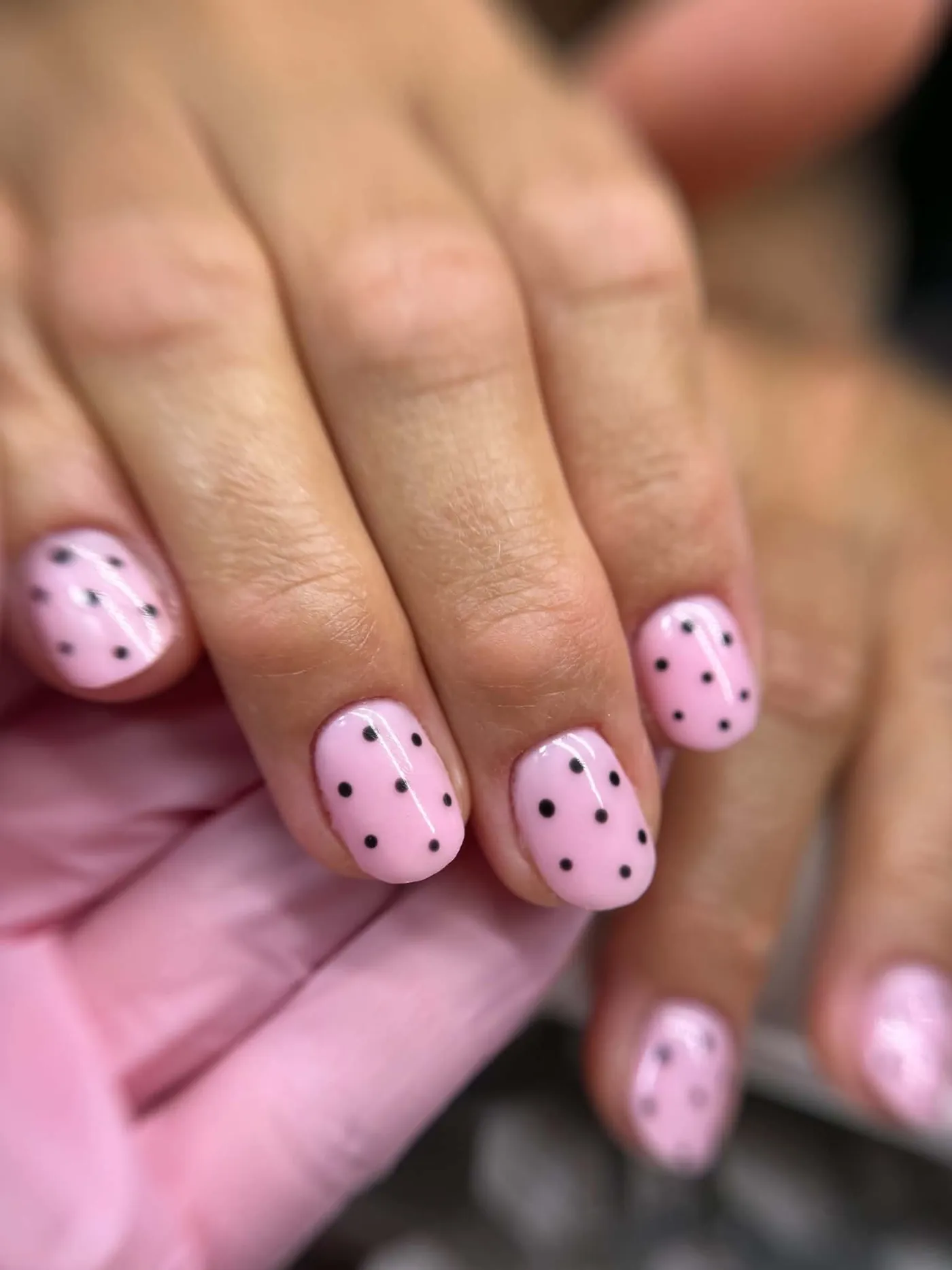 Pastelowo-różowy manicure hybrydowy w czarne kropki na krótkich paznokciach — OZAYA Nails Kraków